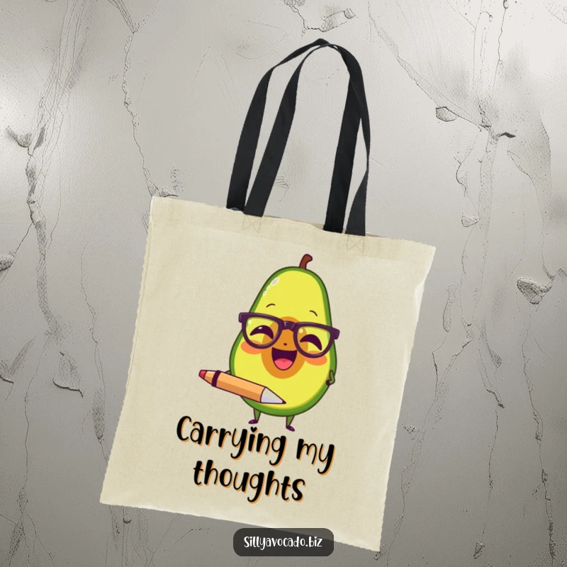 Funny tote bag showcasing an avocado with spectacles, laughing and holding a large pen, perfect for carrying books.